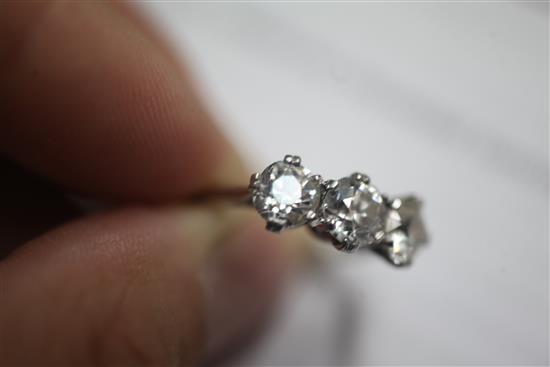 A mid 20th century platinum and three stone diamond ring, size L.